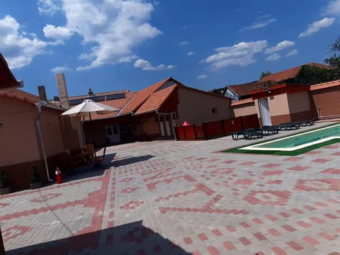 Curtea interioară cu pavaj gri și model roșu de ie, cu piscina în dreapta