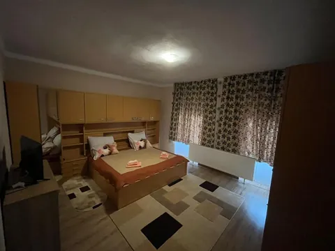 Cameră dublă cu dulap mare de lemn și pat matrimonial