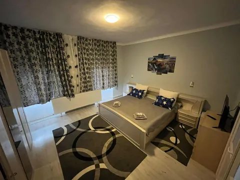 Cameră dublă cu pat matrimonial, draperii cu model și tablou pe perete